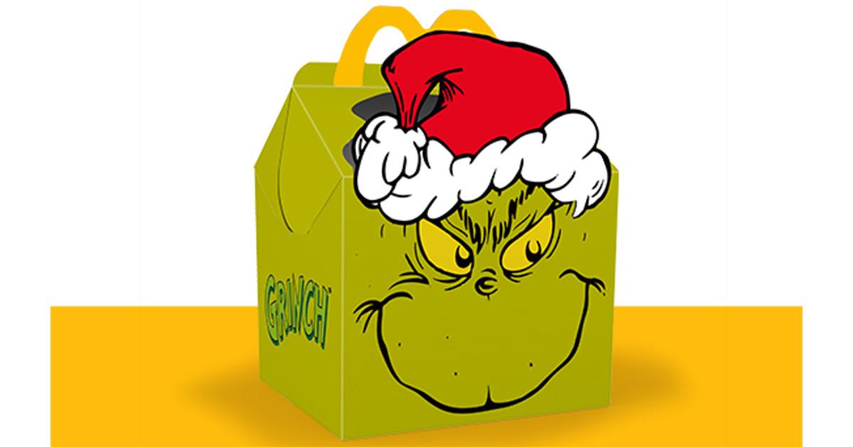 The Grinch Happy Meal box sitting on a yellow surface. 