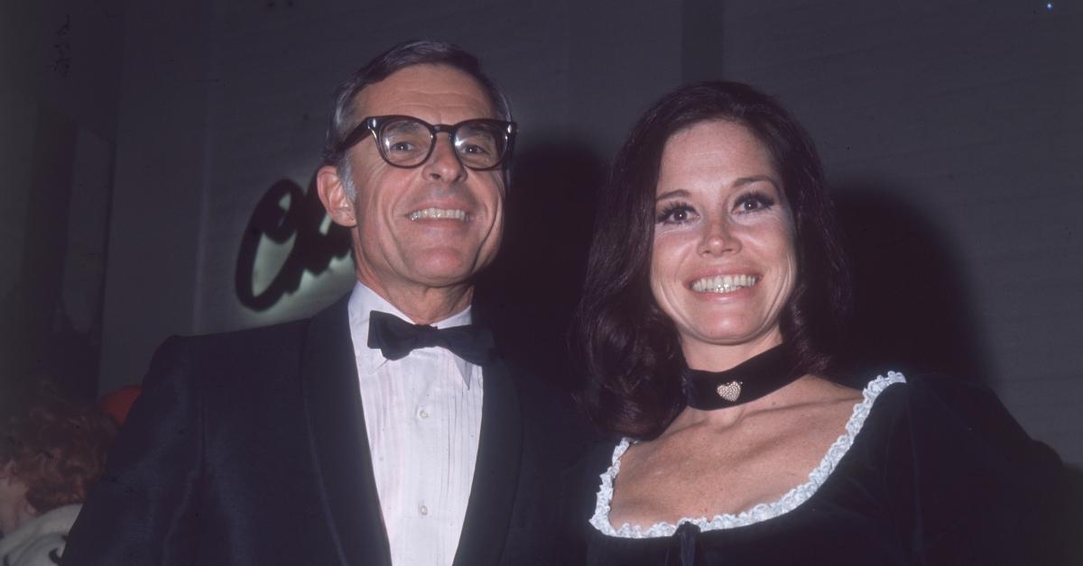 circa 1975: American actor Mary Tyler Moore, in a black dress and choker, and her second husband, American television executive Grant Tinker, standing beside each other and smiling. Tinker is wearing a tuxedo. (Photo by Hulton Archive/Getty Images)