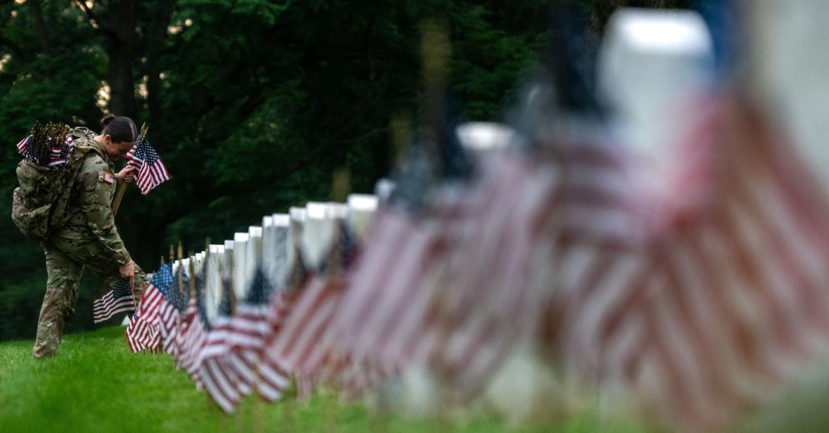 Member of the 3rd U.S. Infantry Regiment placing flags at Arlington National Cemetery on May 23, 2024