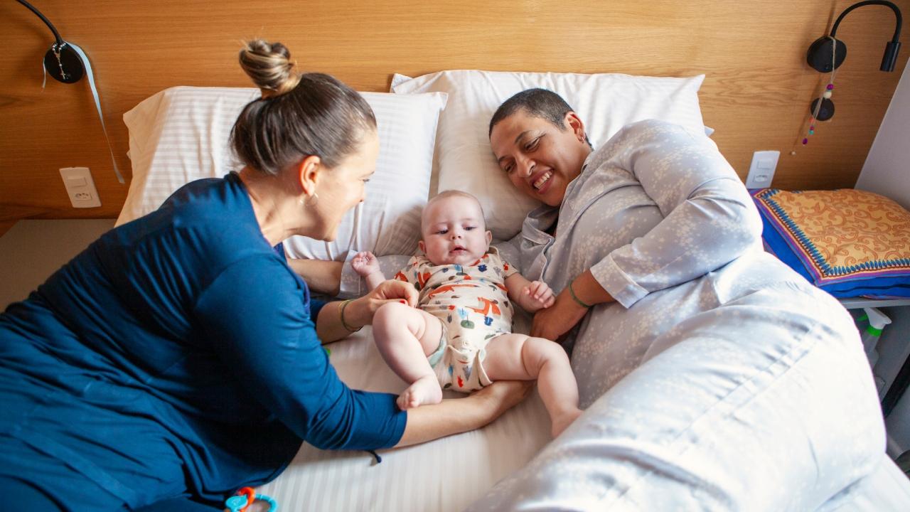 two women with baby in bed