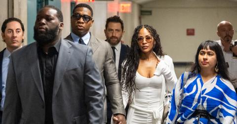 (l-r): Jonathan Majors and Meagan Good walking with his attorneys