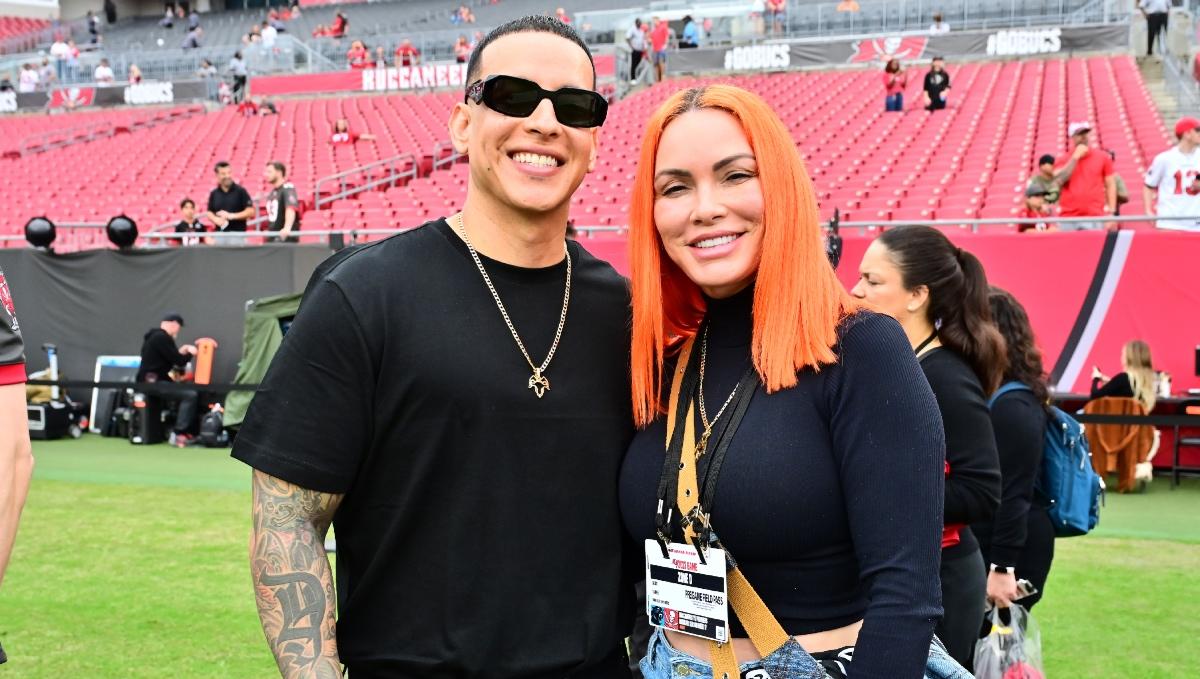Daddy Yankee and his wife, Mireddys González, attend a football game.