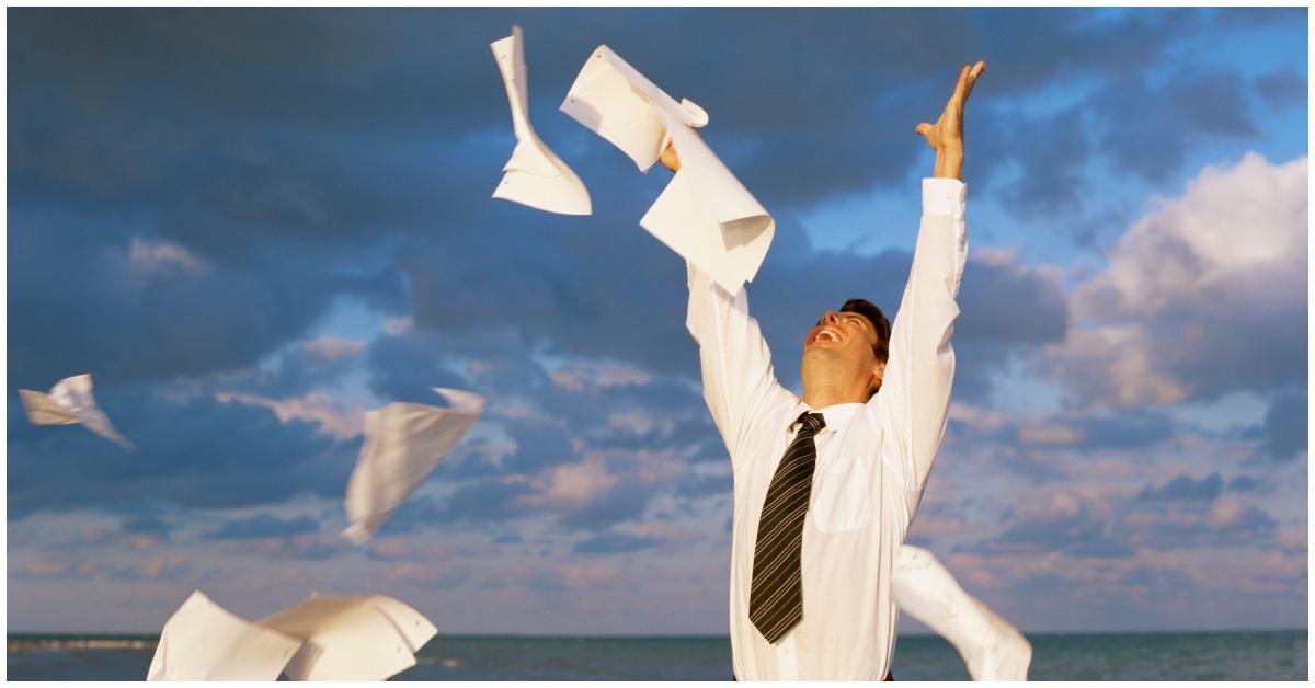 A corporate man throwing papers outside