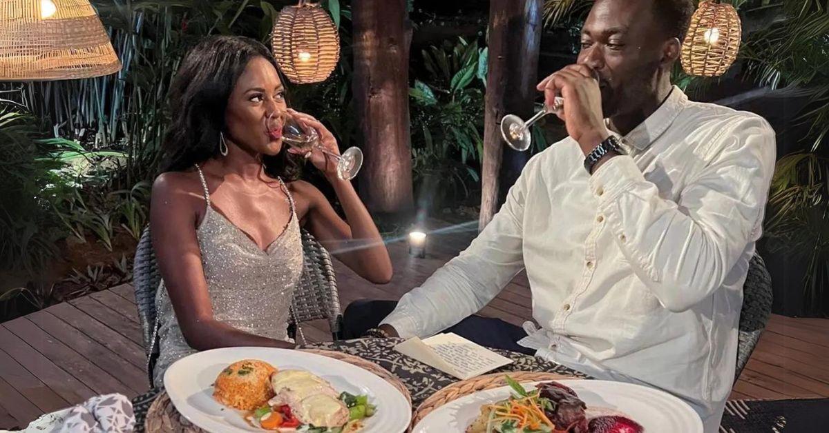 Charity Lawson and Dotun Olubeko drink champagne while seated at dinner with untouched plates of food on 'The Bachelorette'