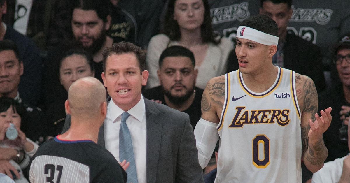 A referee speaking with the coach of the Lakers