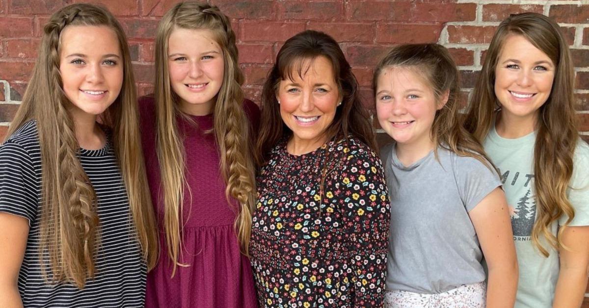 Michelle Duggar and four of her daughters outside, in front of a brick wall