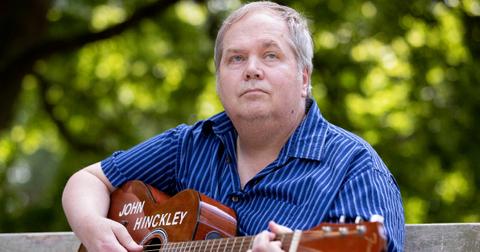 John Hinckley Jr. sits for a portrait with his guitar in Williamsburg, Va.