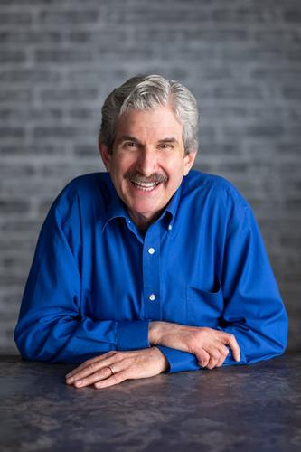 Andy dons a royal blue button-up, smiling for his official portrait for Season 2 of 'The Mole.'