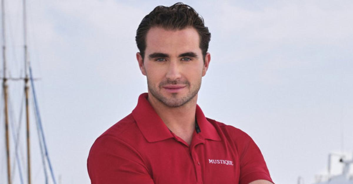 Joe Bradley sports a red 'Mustique' polo while posing on a boat for his official 'Below Deck Med' Season 9 portrait.