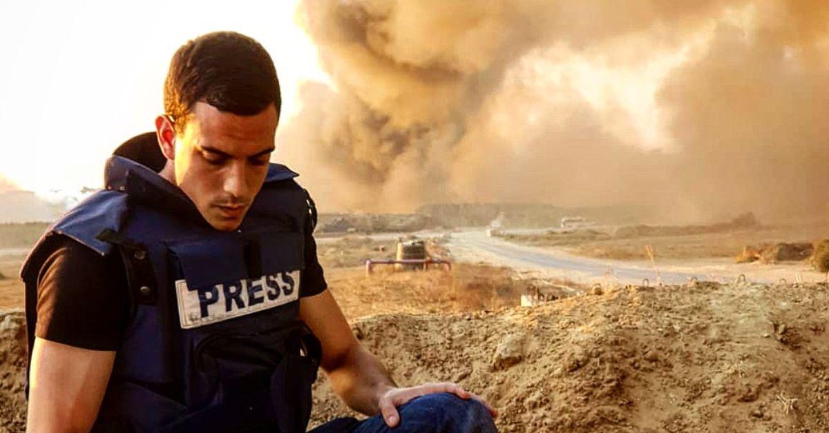 Trey Yingst reporting from Gaza with explosions behind him.