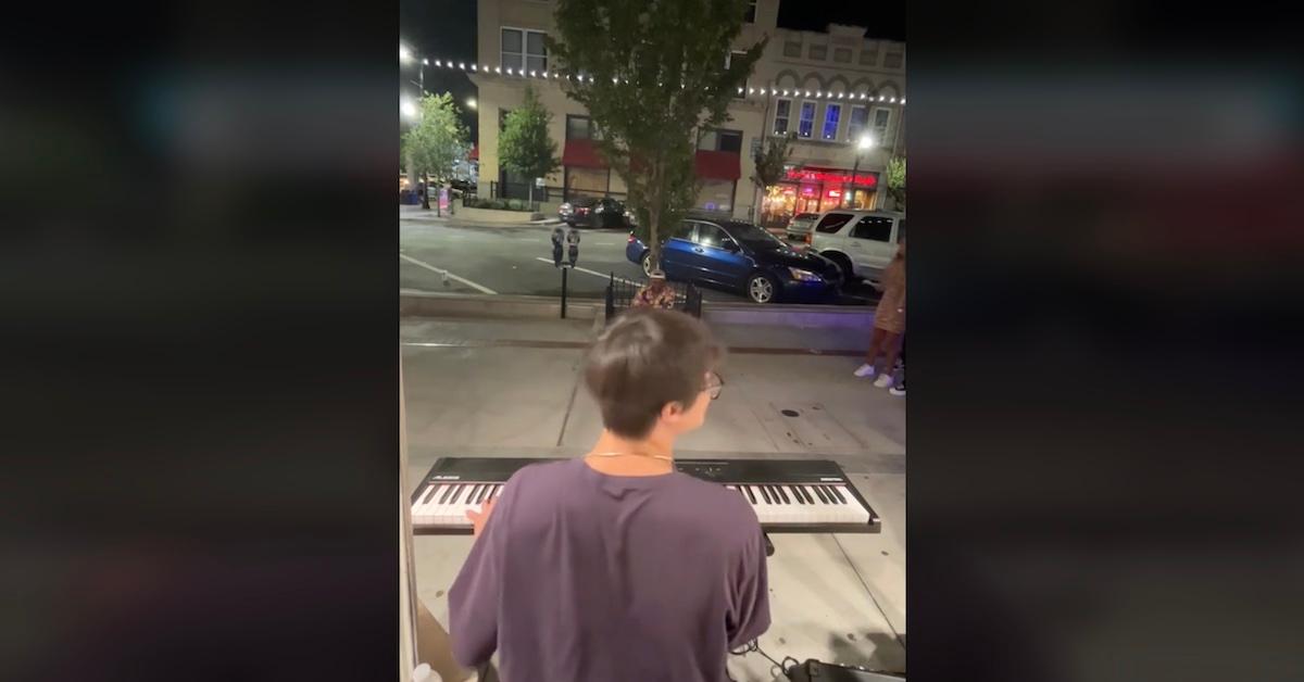 Andrew Shoe playing the piano on a sidewalk