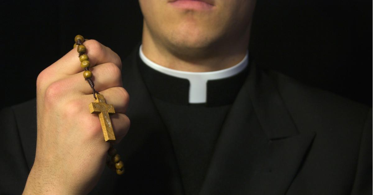 young priest praying picture id