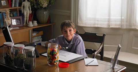 boy at a desk with jar