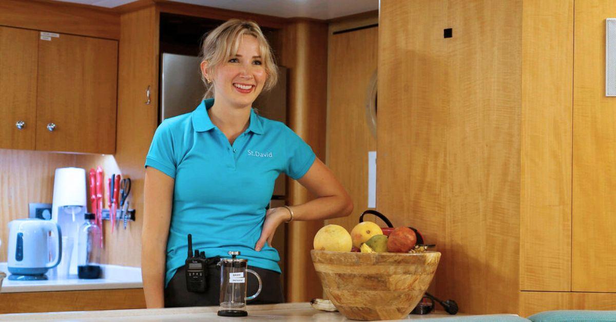 Cat Baugh smiling standing in kitchen on yacht