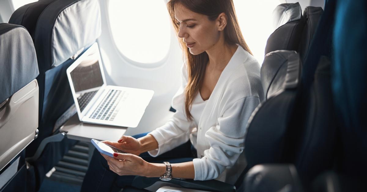 Woman sitting next to an empty seat on a plane.