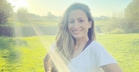 Rebecca Loos in a white t-shirt with the sun behind her.