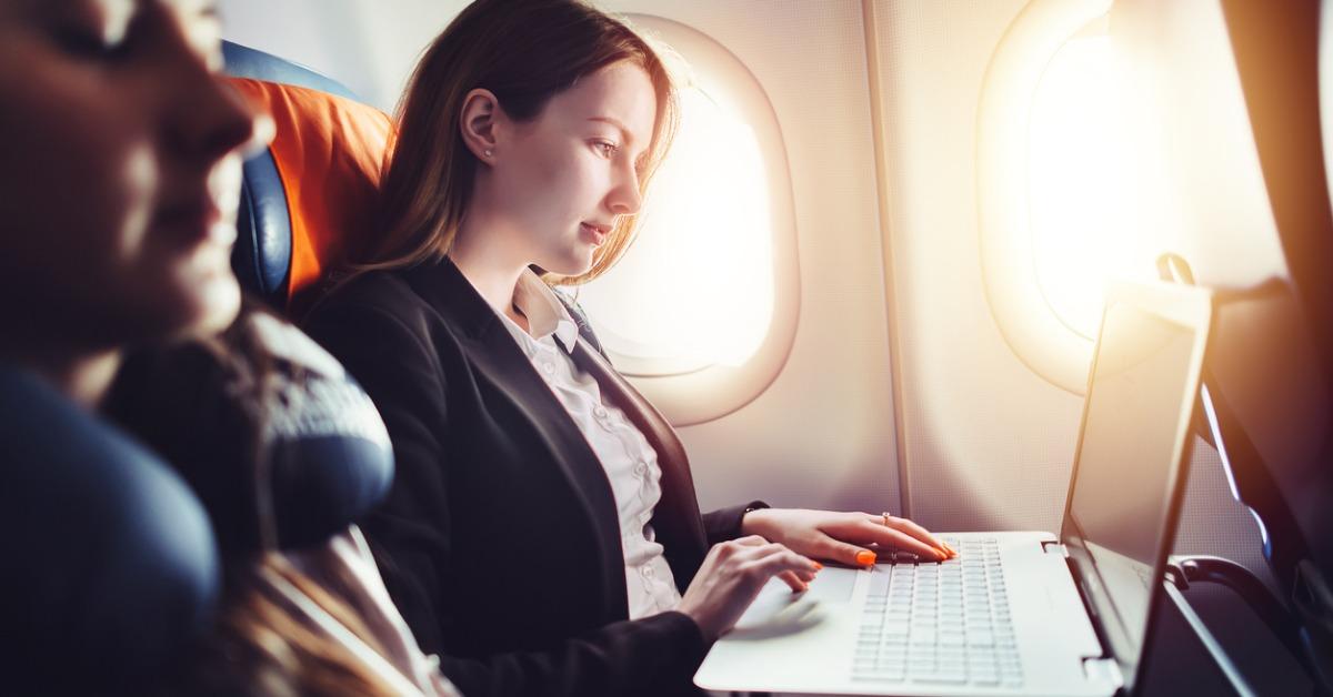 female entrepreneur working on laptop sitting near window in an picture id