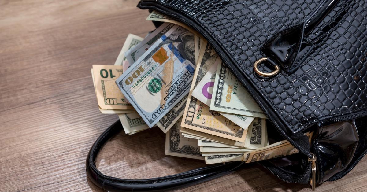 black woman handbag full of money on desk picture id