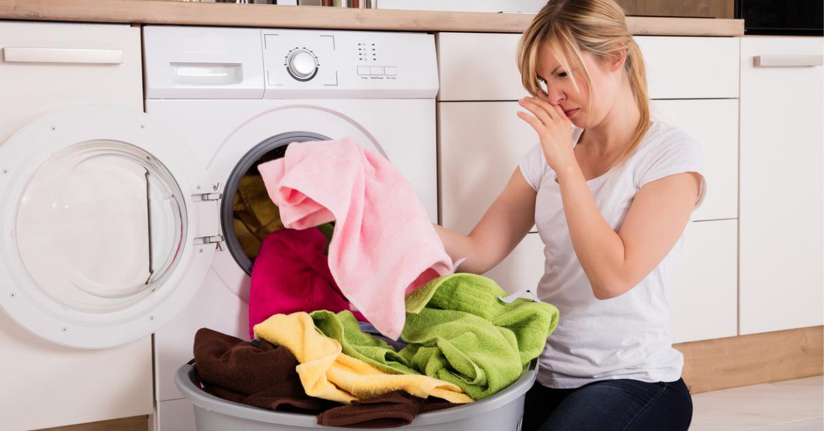 woman unloading smelly clothes from washing machine picture id