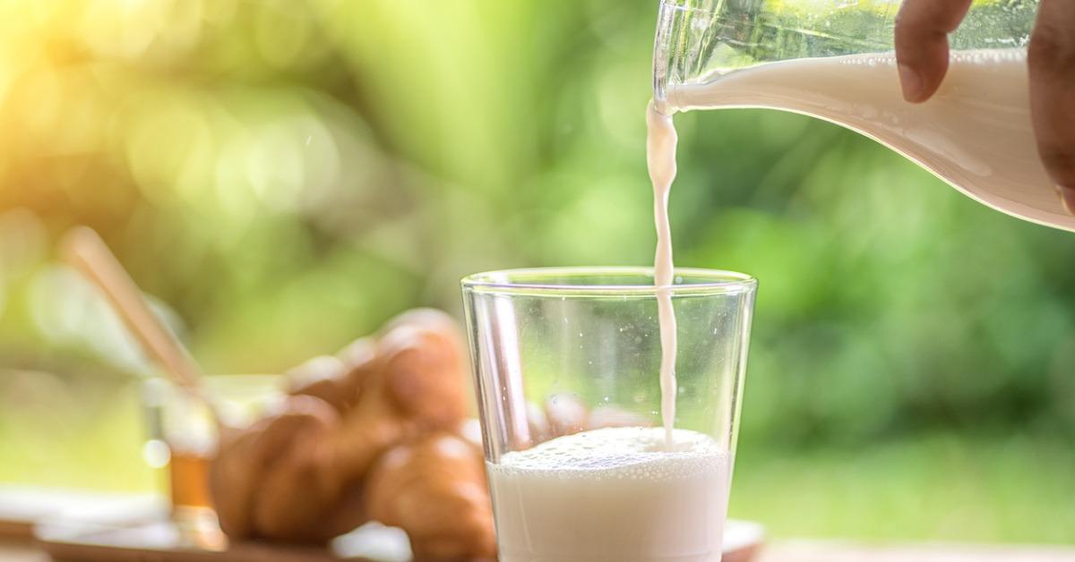 pouring milk in the glass on the background of nature picture id