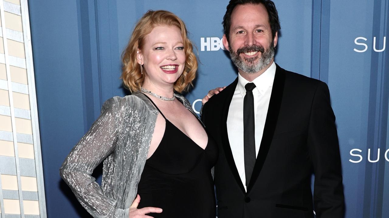 Sarah Snook in a black dress and husband Dave Lawson in a black suit.