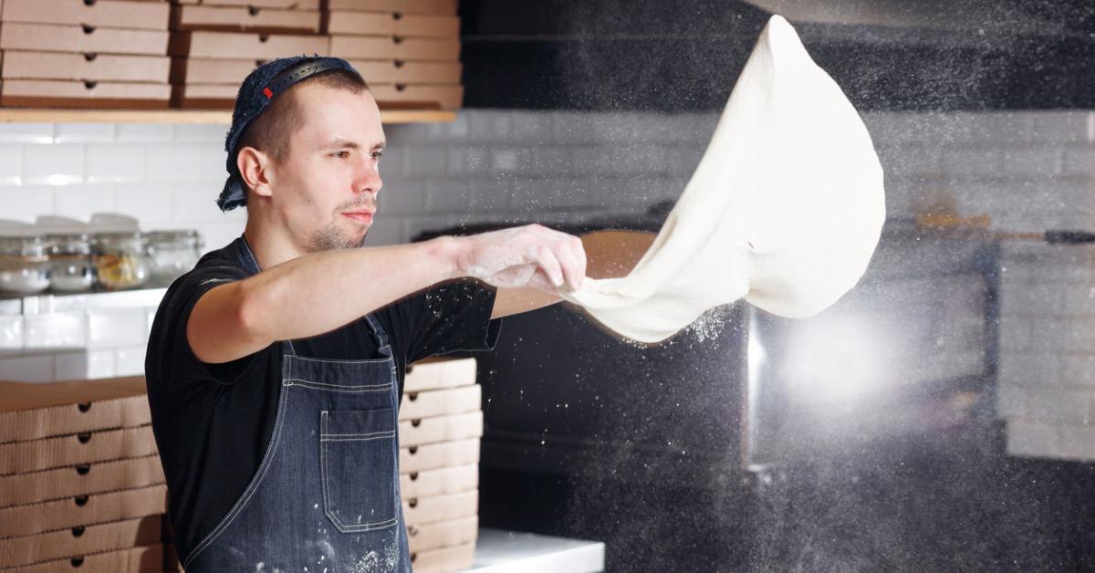 roll out the dough expanding cloud of flour closeup hand of chef in picture id