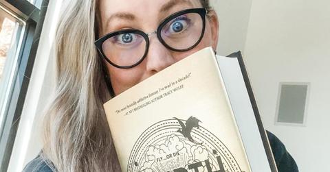 Rebecca Yarros holding a copy of 'Fourth Wing'