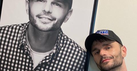 Justin Nettlebeck standing next to a picture of himself at Q101