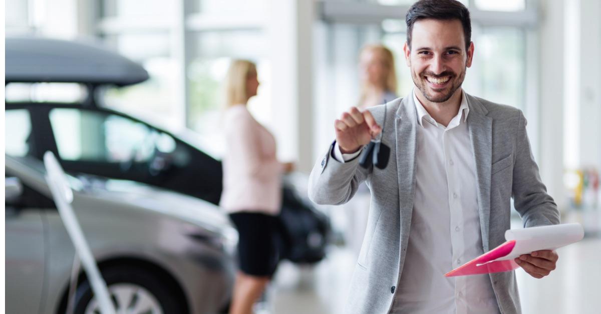 handsome salesman at car dealership selling vehichles picture id