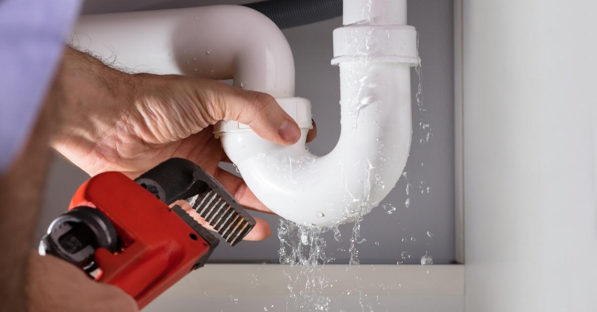 plumber fixing sink pipe with adjustable wrench picture id