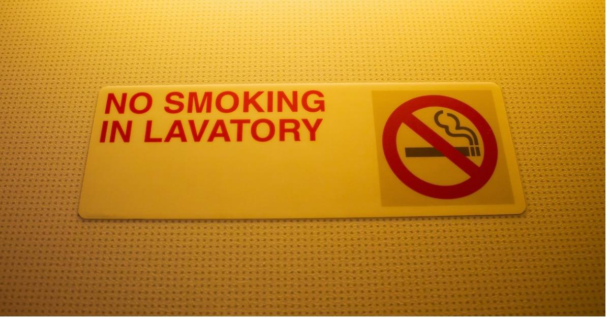 no smoking in lavatory sign warning in toilet on airplane picture id