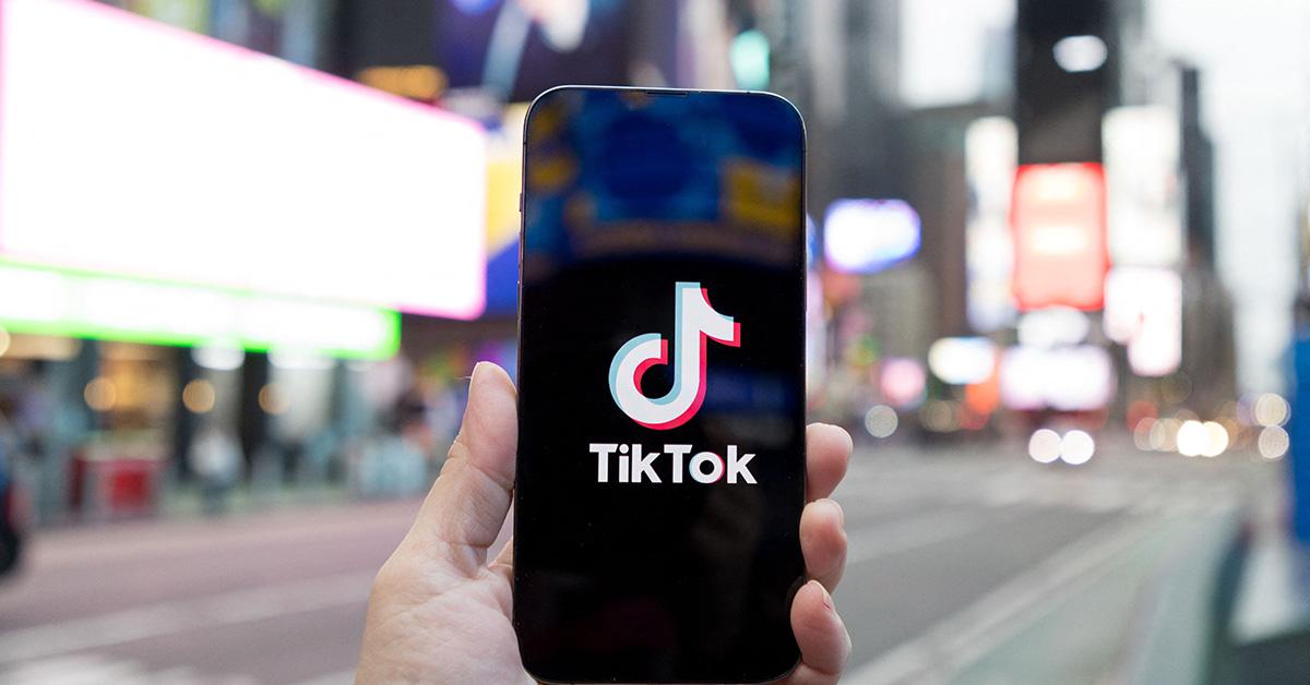 A hand holding a phone with the TikTok logo on it. 