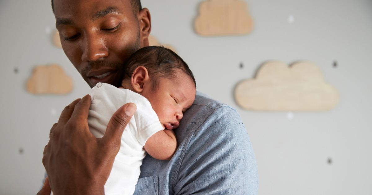 father holding newborn baby son in nursery picture id