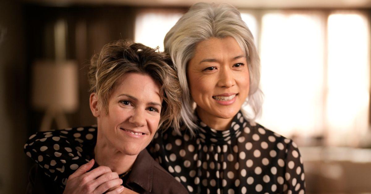 (L-R): Cameron Esposito as Greta and Grace Park as Katherine hugging and smiling