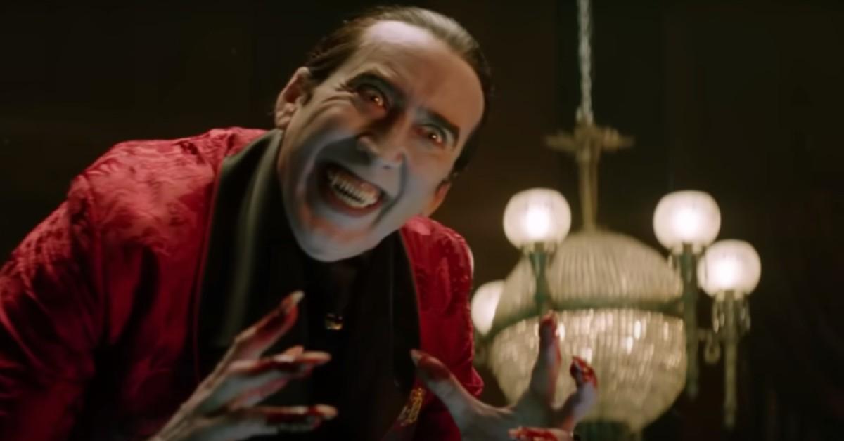 The red-cape clad Dracula (Nicolas Cage), grins with blood on his hands