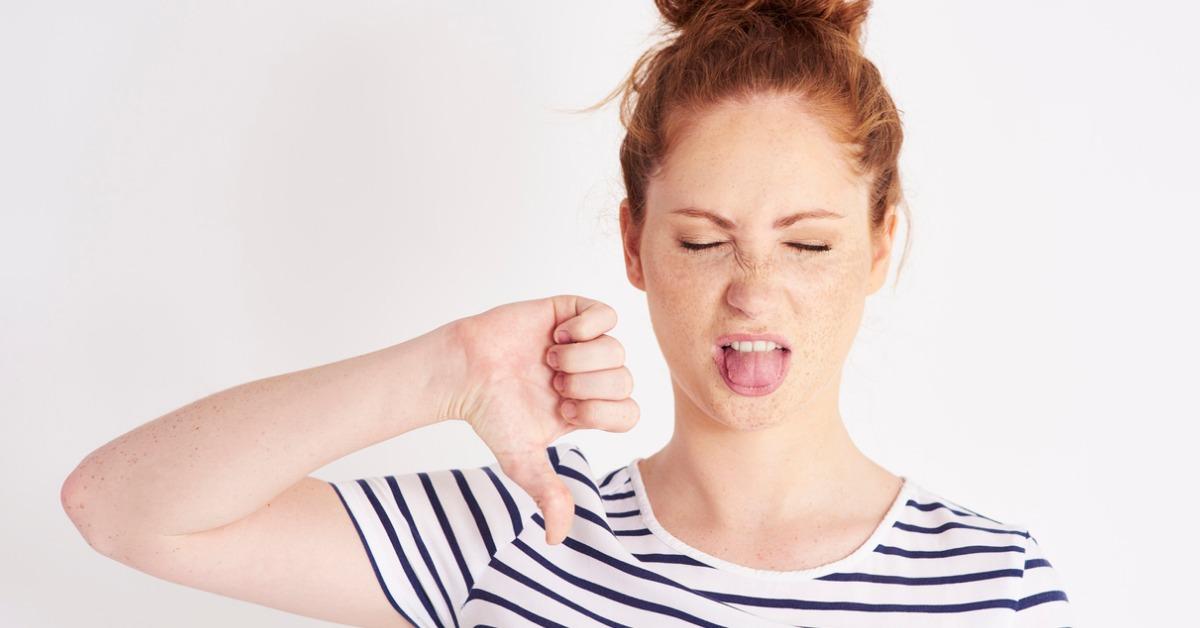 woman showing thumb down and grimacing at studio shot picture id