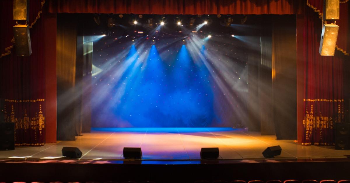 an empty stage of the theater lit by spotlights and smoke picture id