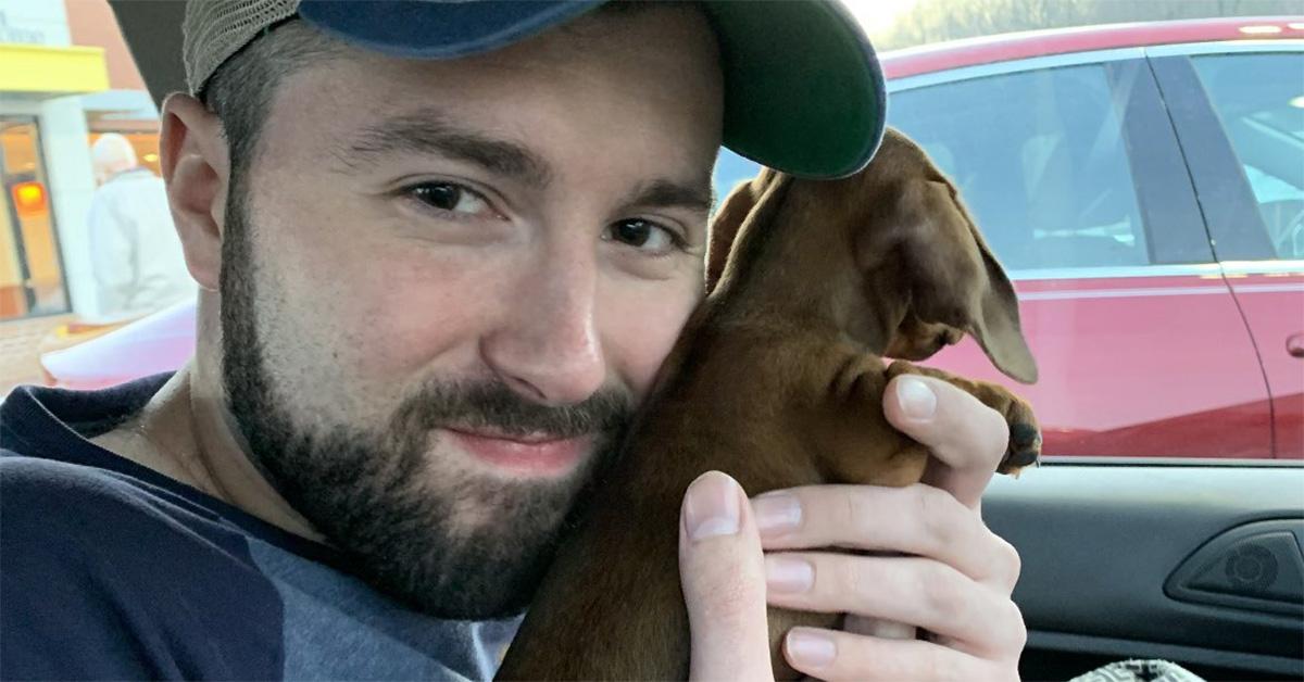 Matt Napolitano holding a small dog in a car