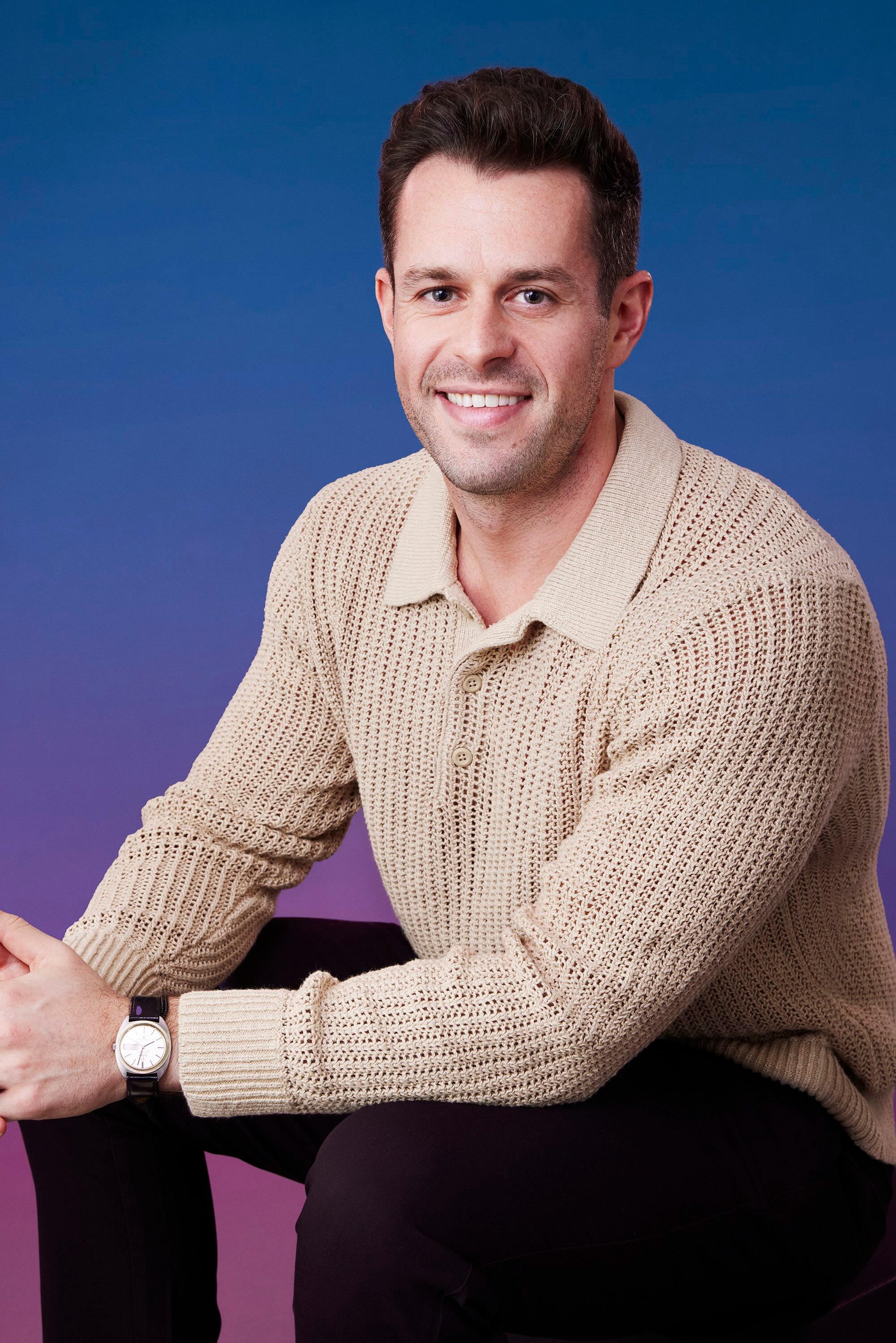 Jeremy poses in front of a blue-purple ombré background for his official 'The Bachelorette' Season 21 portrait.