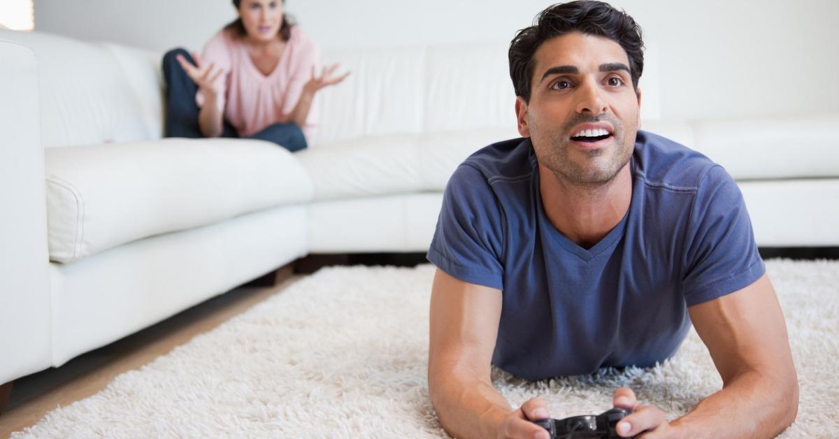 man playing video games while his fiance is getting mad at him picture id