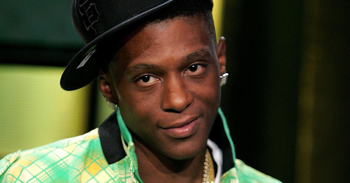 Lil Boosie in a hat and a green plaid jacket.