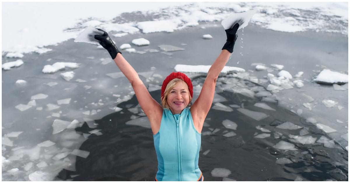 A woman in icy water with a vest and underwear on