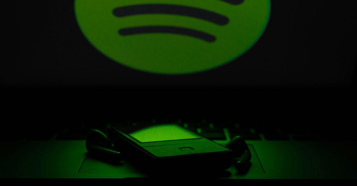 The Spotify logo over an MP3 player. 