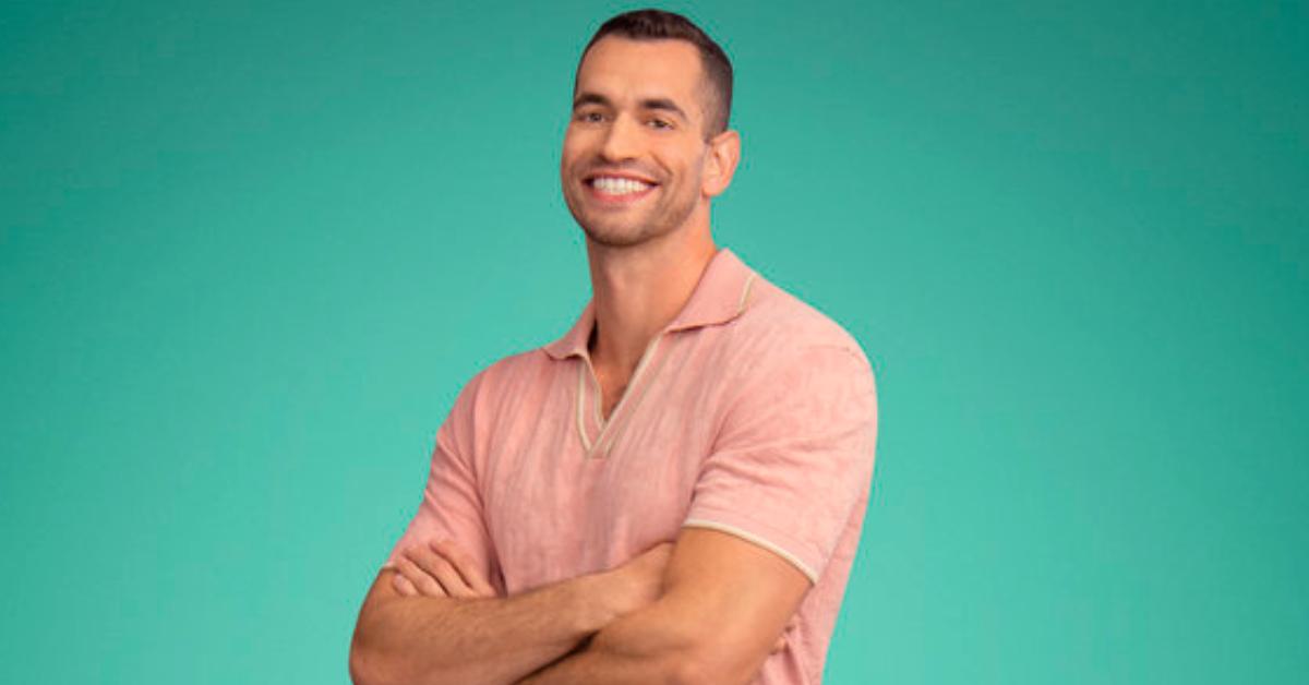 Jesse Solomon smiles and poses for Season 8 of 'Summer House' in a light pink collared short sleeve shirt.