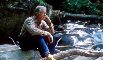 Jimmy Carter sitting on a rock near a creek in 1988.