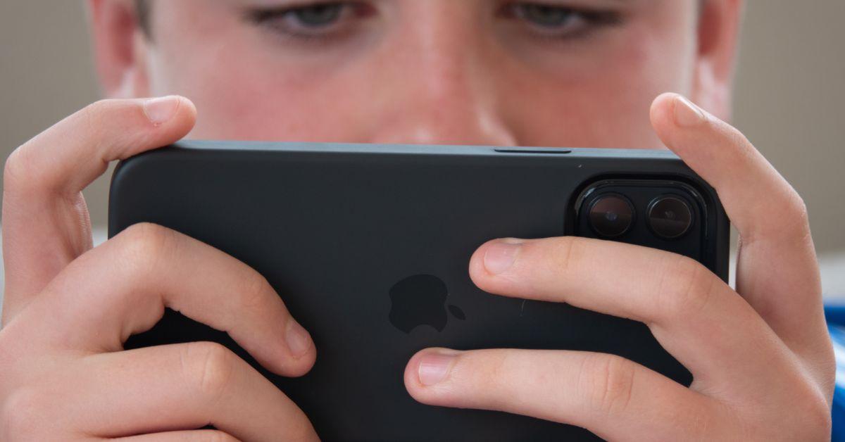  A 12-year-old boy looks at a iPhone screen