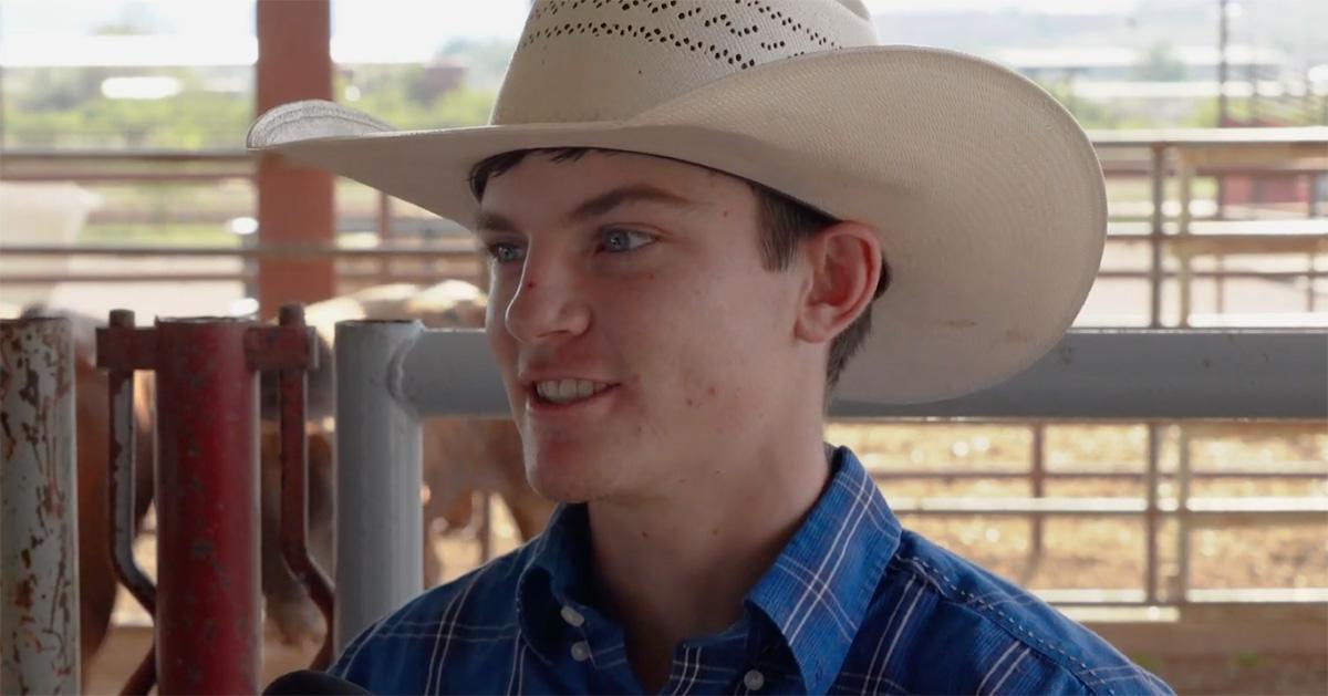 Ky Hamilton giving an interview in front of stables. 