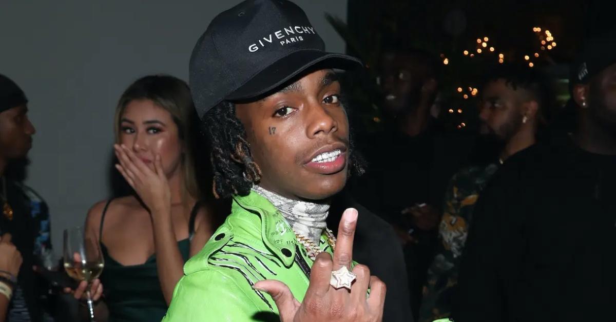 YNW Melly in a green jacket and black Givenchy hat.