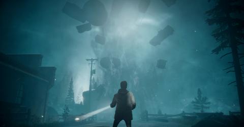 'Alan Wake' Close-up of Alan Wake with a flashlight in front of a dark tornado.