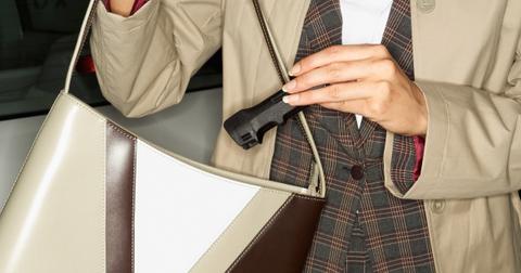 A woman putting pepper spray in her purse